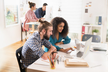 At office of a startup, a young multi-ethnic team works on diffe