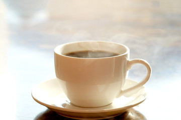 Morning of a new day, Hot coffee, cappuccino with smoke in glass placed on the table.