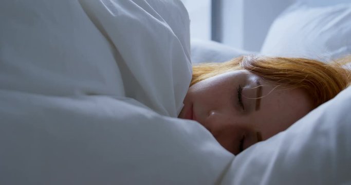 Woman sleeping in bedroom at home