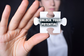 Businessman holding a puzzle with the inscription:UNLOCK YOUR POTENTIAL