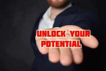 In the hands of a businessman the inscription:UNLOCK YOUR POTENTIAL