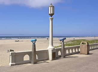 Monoculars and a light post overlooking the beach.