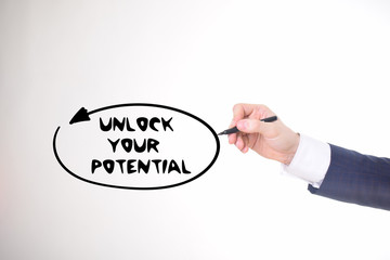 The businessman writes a black marker inscription:UNLOCK YOUR POTENTIAL