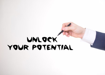 The businessman writes a black marker inscription:UNLOCK YOUR POTENTIAL