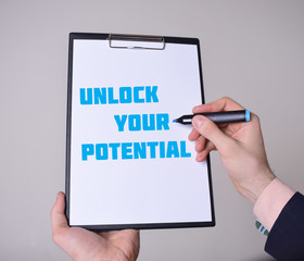 A businessman shows an inscription:UNLOCK YOUR POTENTIAL