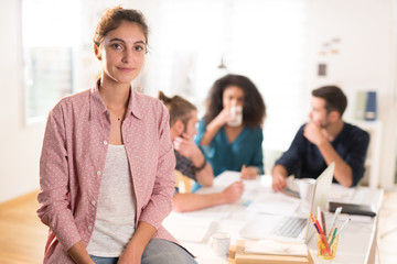 At office. Portrait of a young woman looking at the camera. In t