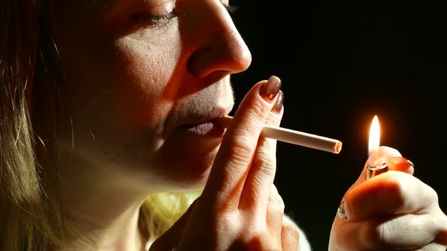 4K.Woman  do fire with lighter and cigarette . Close up 