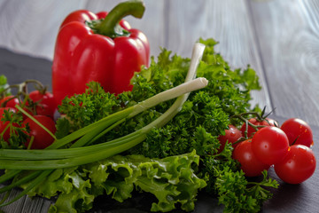 Salad, red pepper and tomatoes on a black board.