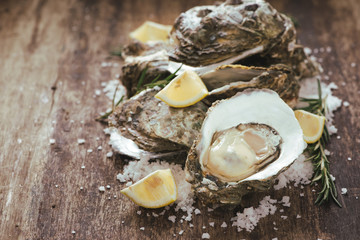 A photo of freshly opened oysters on a wooden background texture with copyspace
