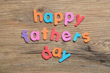 Happy fathers day on a wooden background