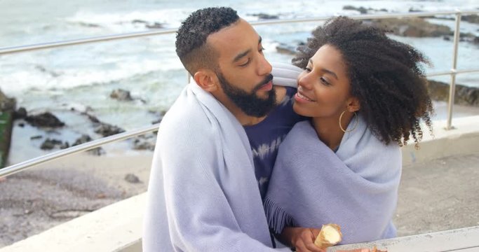 Couple having ice cream cone at beach 