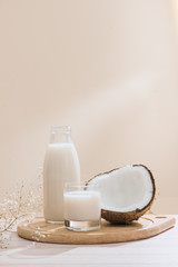 Coconut milk in bottle and glass on table with copy space