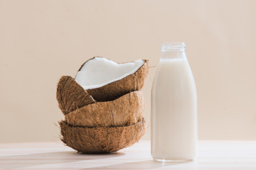 Coconut milk in bottle and glass on table with copy space