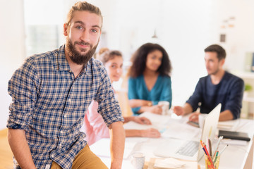 At office. Portrait of a young man looking at the camera. In the