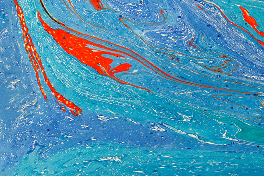 Creative abstract art background in blue tones with red lines and spots. Modern art. Acrylic painting. Liquid paint.