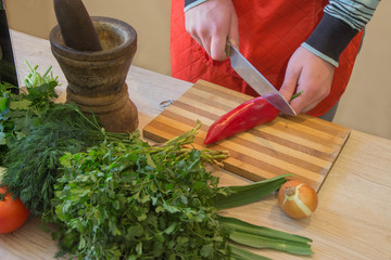 Chef cuts the vegetables into a meal. Preparing dishes. A Man uses a knife and cooks. Male's hands cutting bell pepper