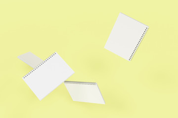 Four notebooks with spiral bound on yellow background