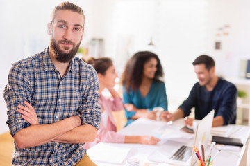 At office. Portrait of a young man looking at the camera. In the
