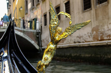 closeup of statuette in gold color on Venetian gondola