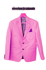 Beautiful pink groom's jacket hanging on the white wall. Groom’s accessories