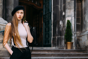  girl with long hair looks distant and holds the bag behind the