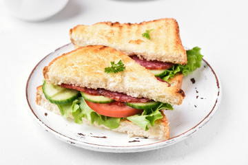 Club sandwiches with salami, tomatoes, cucumber and lettuce