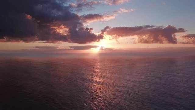 Flying to setting sun in dramatic clouds over Atlantic ocean, 4k
