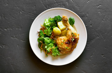 Baked chicken leg with potato and green salad