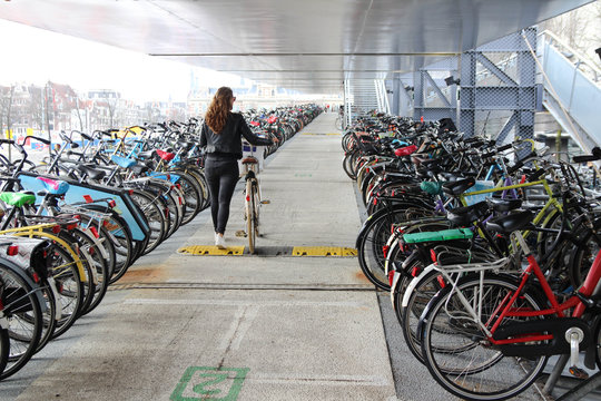 A young woman in the parking of a bicycle