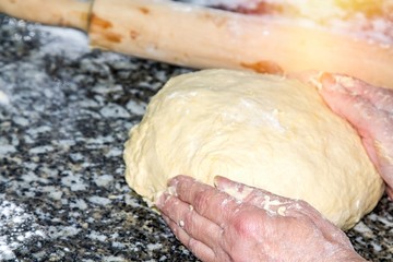 woman kneading dough with rolling pin
