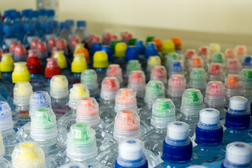 Drinking water, multi-colored plastic cap. Bottle caps on the market close up.