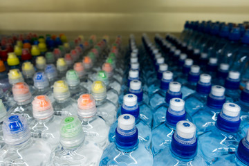 Drinking water, multi-colored plastic cap. Bottle caps on the market close up.
