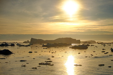Icebergs in the light of the rays of the sunset