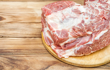 Cutting board with raw meat on wooden table. Copy space.