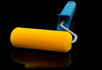 Paint roller on black reflective background.