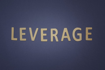 Leverage written with wooden letters on a blue background