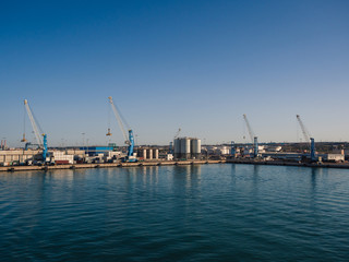 Obraz premium Shipping industrial trade port. Crane bridge and import export container at shipping port harbor.