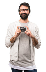 Happy Hipster man holding a camera on white background