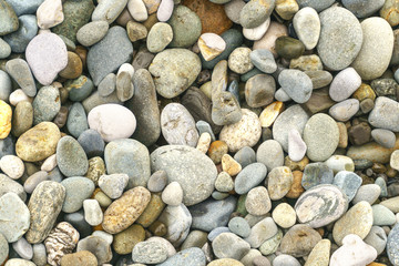 Smooth round pebbles sea texture background. Pebble on a beach. Gravel stone seashore.