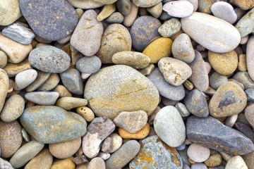 Smooth round pebbles sea texture background. Pebble on a beach. Gravel stone seashore.