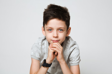 portrait of the thoughtful boy on gray background. Thoughtful teenager.