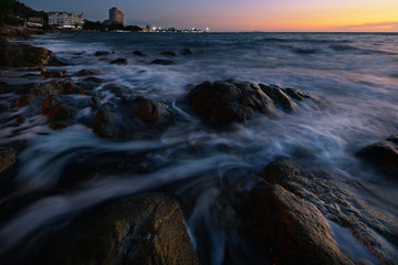 wave at the sea on the rock with sunset sky