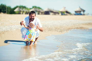 Fototapeta premium Happy father and his sweet little daughter at beach