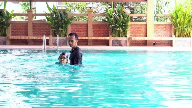 Father teaches daughter to swim