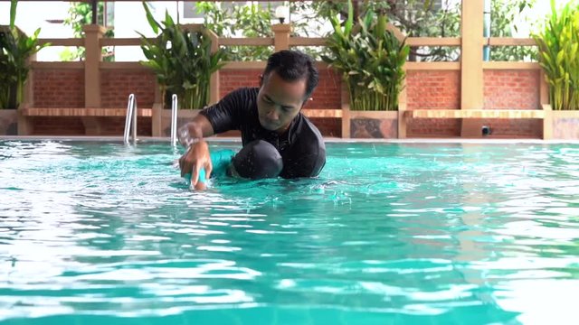 Slow motion Father teaches daughter to swim
