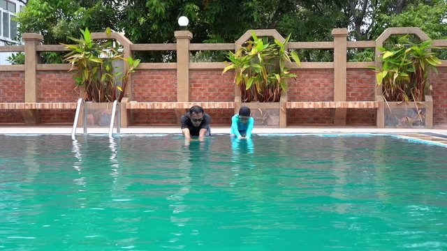 Slow motion Father teaches daughter to swim