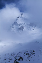 Fototapeta na wymiar Szczyty wysokich gór wychodzą z mgły