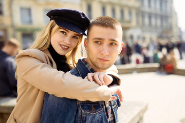 Lovely couple stand on city landscape and hug each other with sun on background