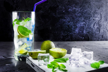 Mojito in glasses, next to lime and mint on the cutting Board. Copy space.