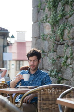 Man sitting on outdoor terrace drinking coffee